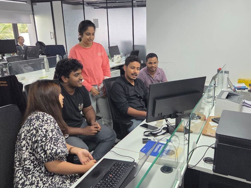 The Quanfluence engineering team reviewing work together at their desks in Bengaluru